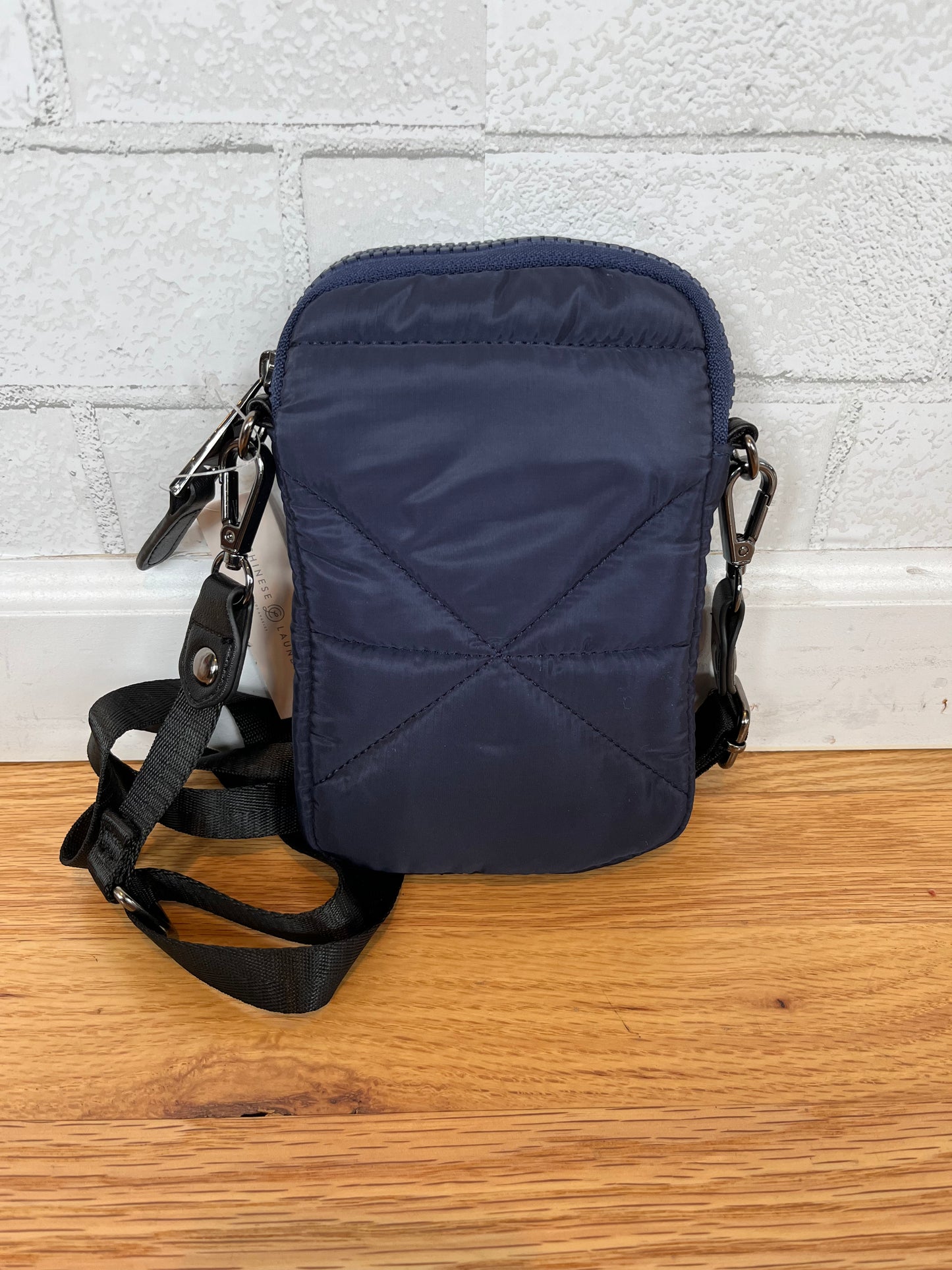 A phone crossbody bag with a thin adjustable strap. Zipper on the outside and a pocket in the front.  